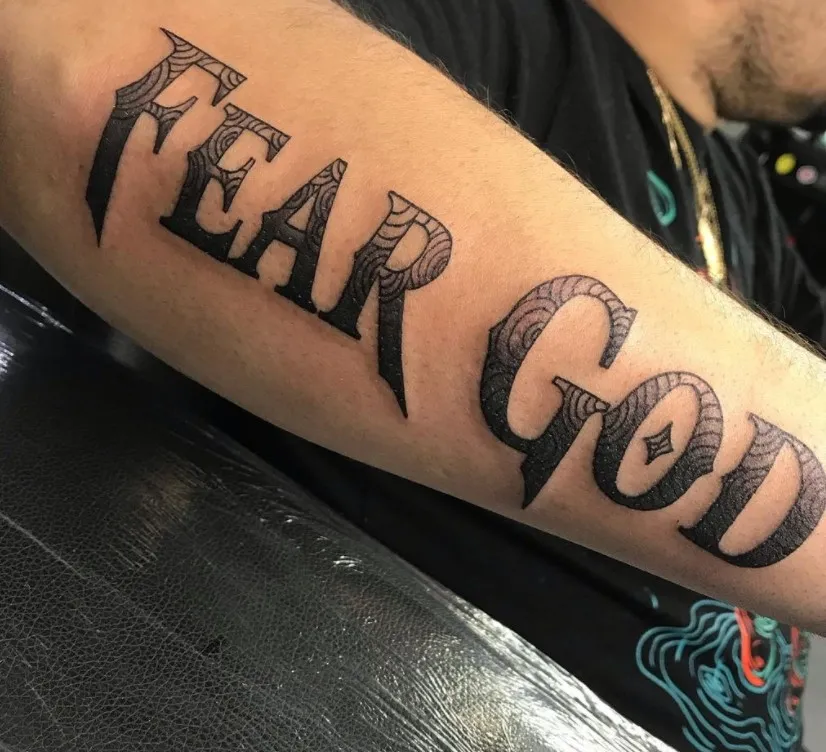 detailed fear god tattoo on arm