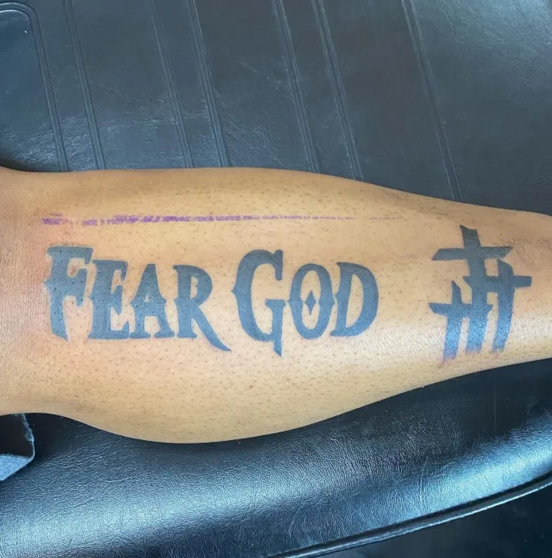 fear god tattoo on leg