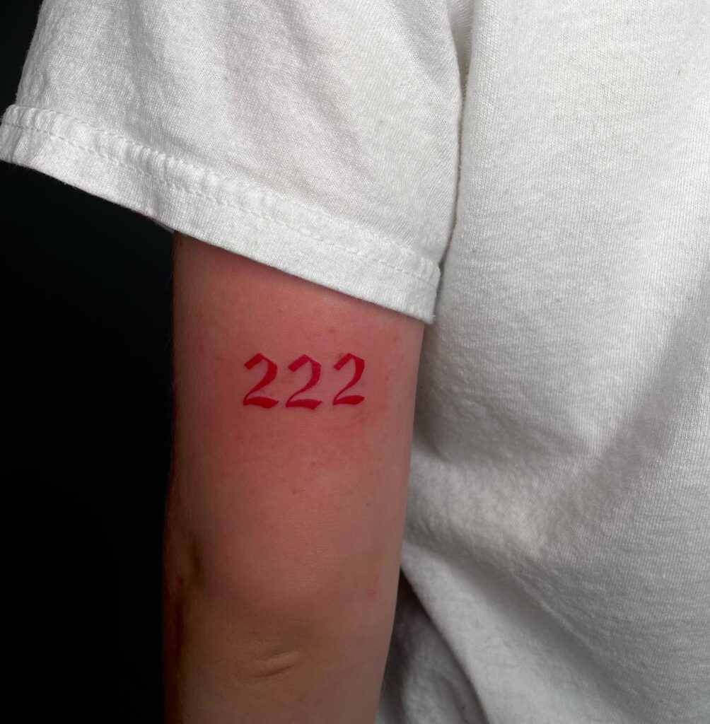 red 222 tattoo outer arm