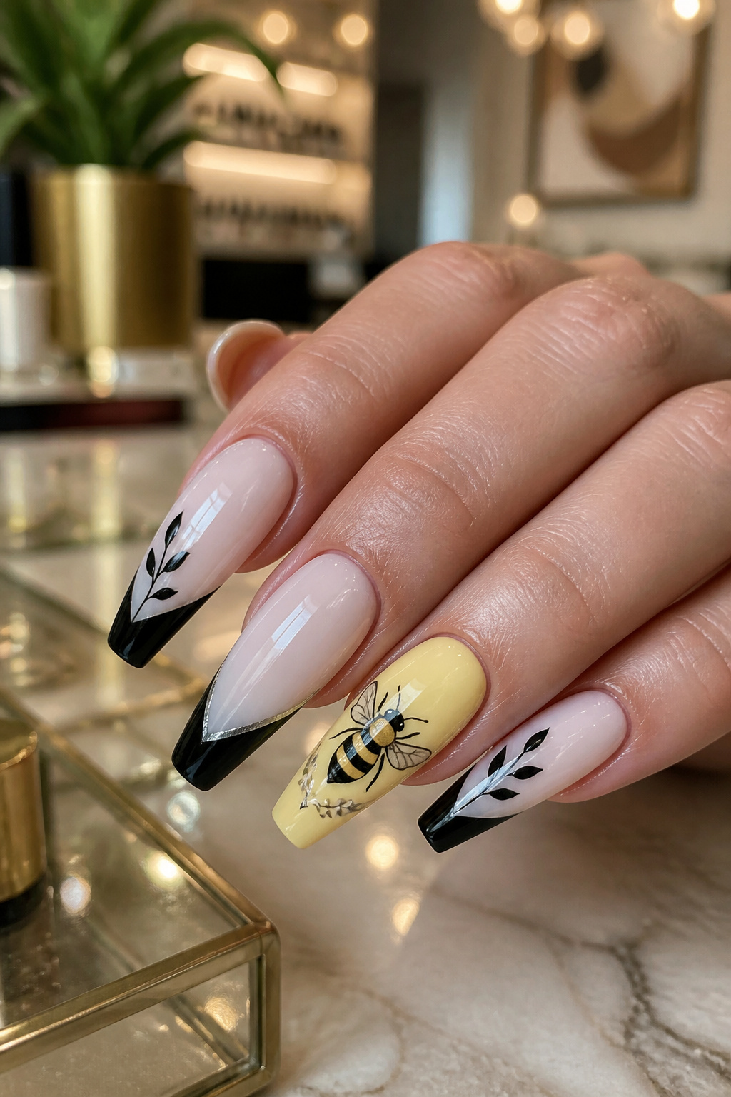 Ballerina-shaped nails with black and white bee designs and one pale yellow accent nail.