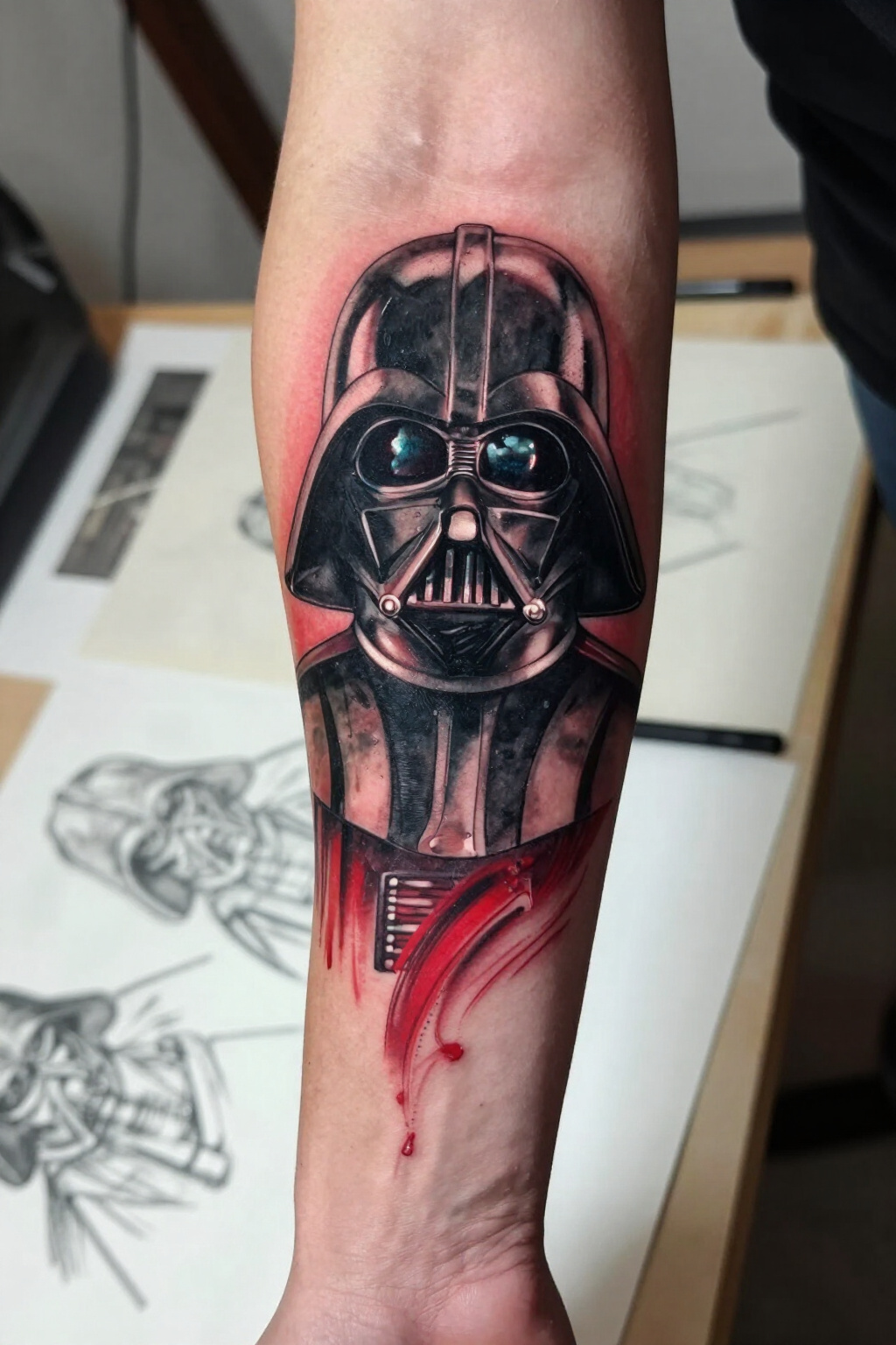 Sketch tattoo of Darth Vader's mask in red and black.