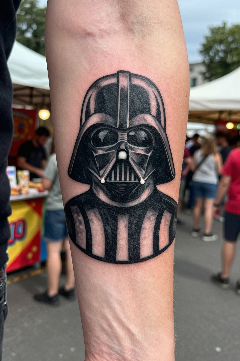 Silhouette tattoo of Darth Vader's helmet on skin.