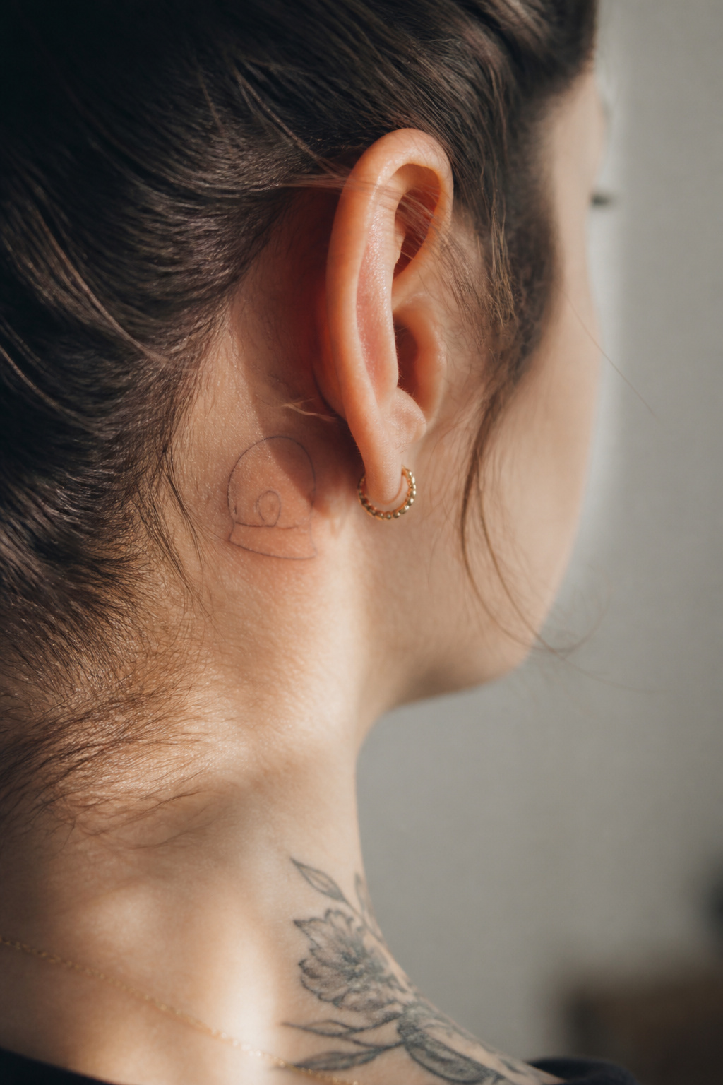 Minimalist tattoo representing Daft Punk's helmet with a single line.