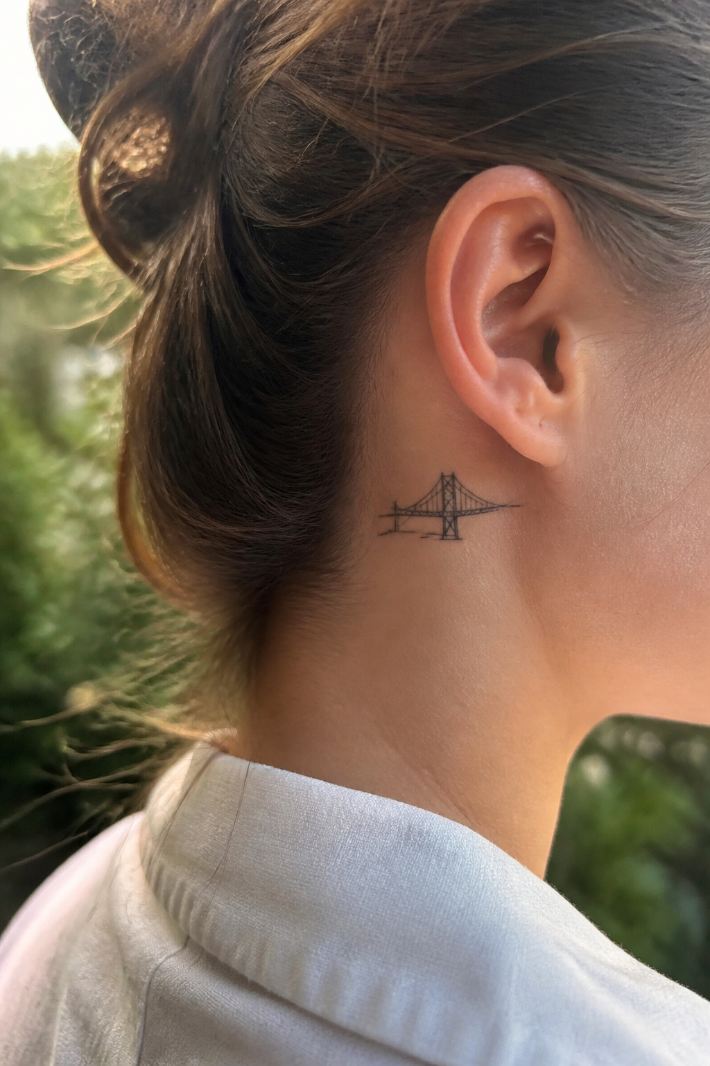 Tiny bridge tattoo inked behind a model's ear.