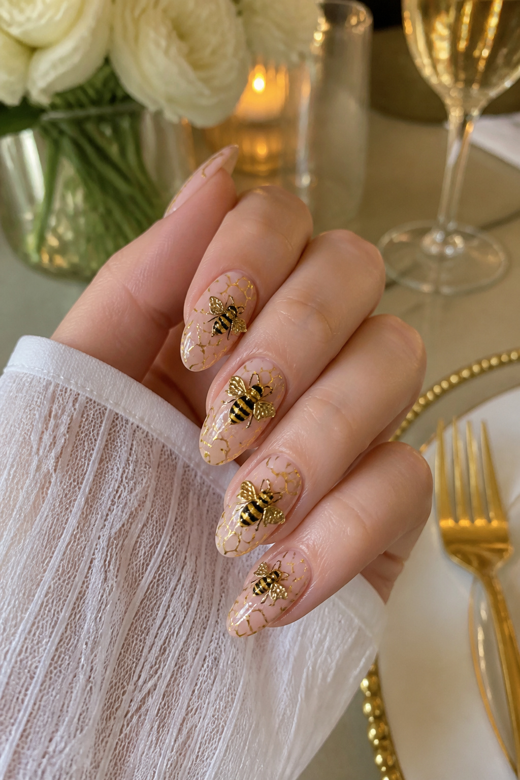 Nails with a honeycomb base and prominent 3D bee charms on accent nails.