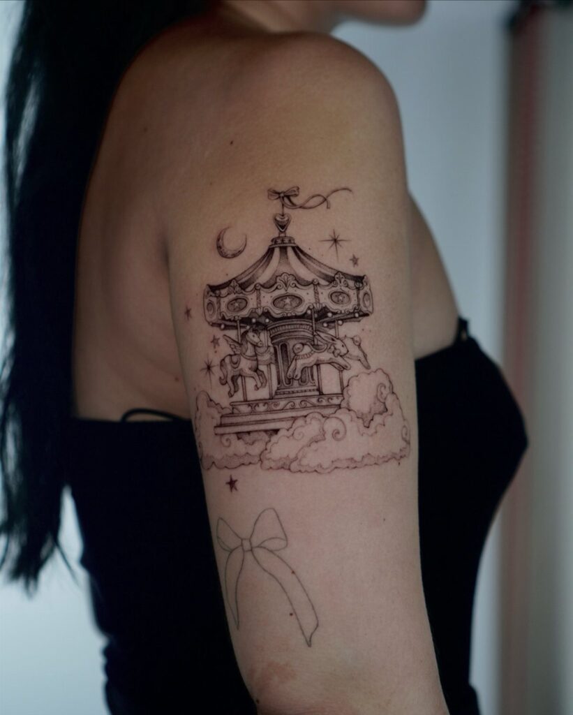 A fine-line black ink tattoo of a whimsical carousel on a person's upper arm.