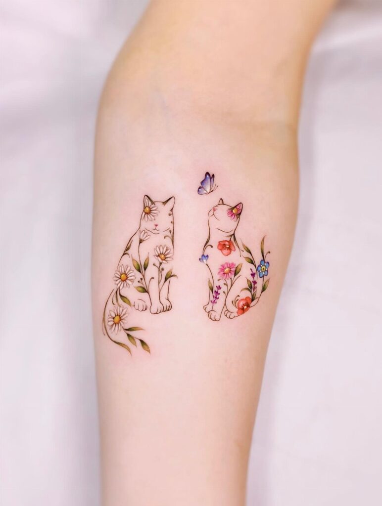 Two small cat tattoos featuring colorful floral patterns and a butterfly on a person's arm.