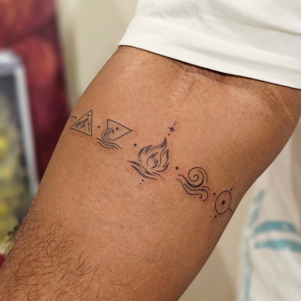Minimalist elemental tattoos in black ink arranged in a line on a person's forearm.