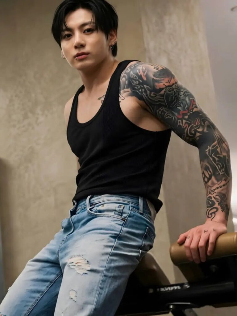 A young man with dark hair and a large sleeve tattoo on his left arm.